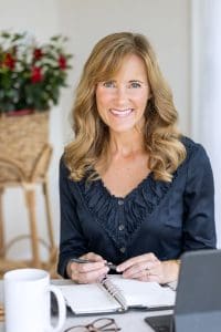 Photo of Seana Turner sitting at a desk holding a pen talking about what your professional organizer wants you to know.


