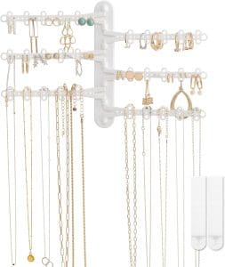 A wall-mounted white metal rack with 6 swinging arms for holding jewelry of various sizes.