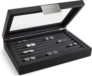 A black box with the lid opened and displaying storage cushions that hold cufflinks.