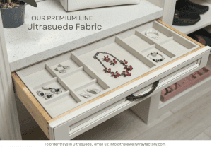 An open drawer with one large, velvet-lined insert that holds various types of jewelry.