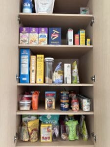 Pantry shelves after being organized. Movement of shelves allows all the content to sit properly and upright on the shelves.